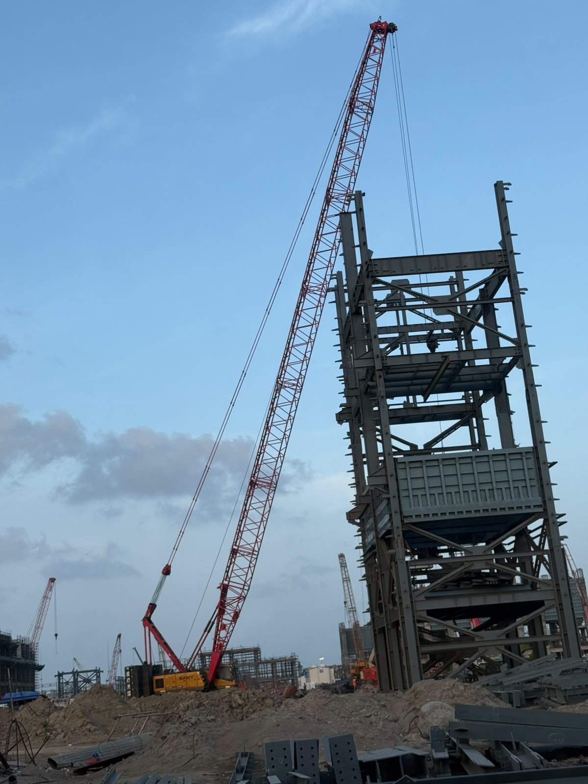 Crawler crane beside a steel industrial structure